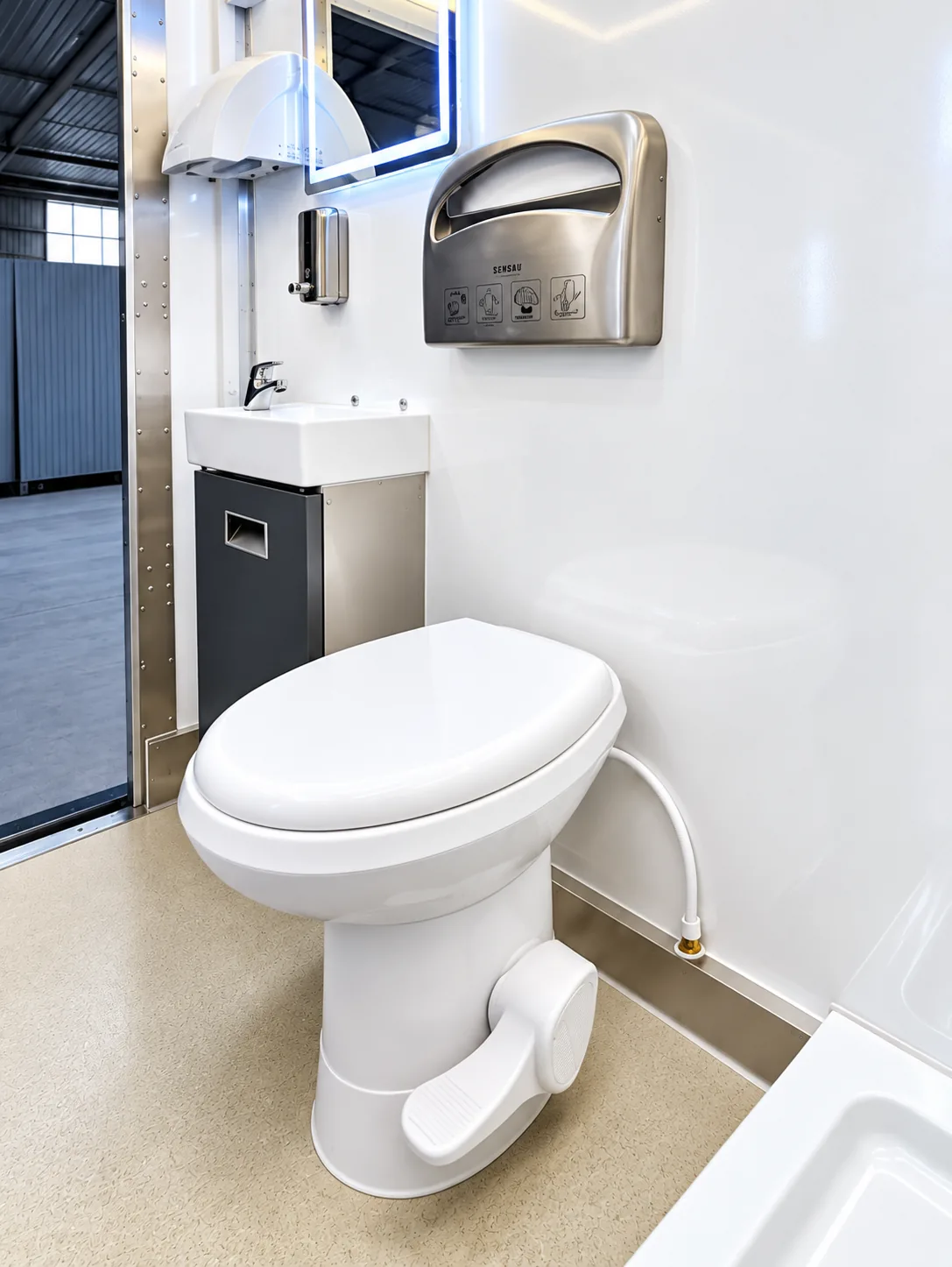 Sink and toilet fixtures inside a portable restroom trailer